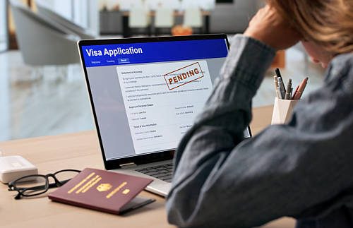 Woman Anxiously Checking Real-time Visa Application Status On Laptop Screen.