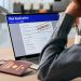 Woman Anxiously Checking Real-time Visa Application Status On Laptop Screen.