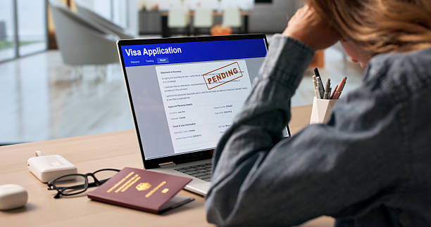 Woman Anxiously Checking Real-time Visa Application Status On Laptop Screen.